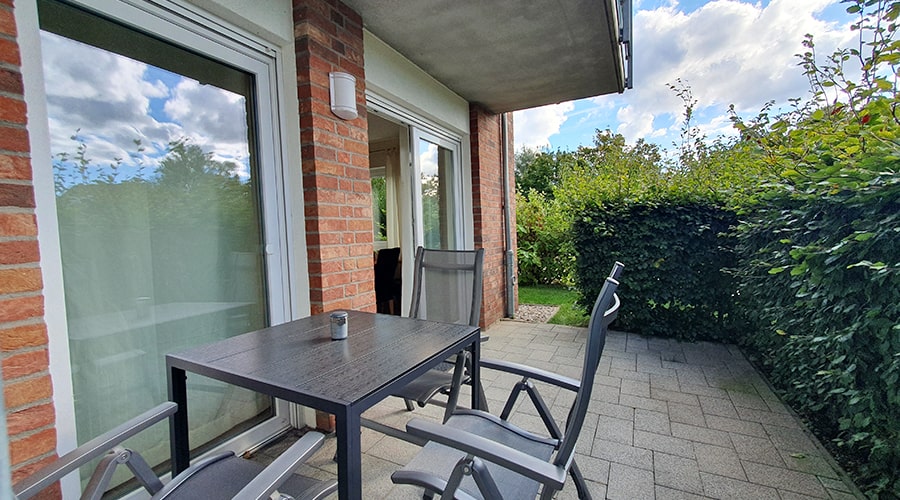 Balkon mit Tisch, Stühlen und Blick auf Ferienwohnungen